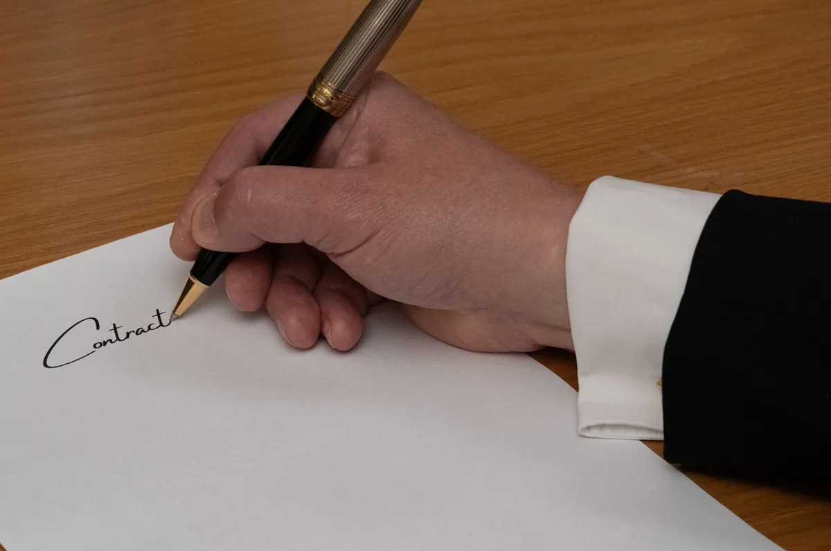 Firma de contrato en la venta de una empresa con asesoría financiera